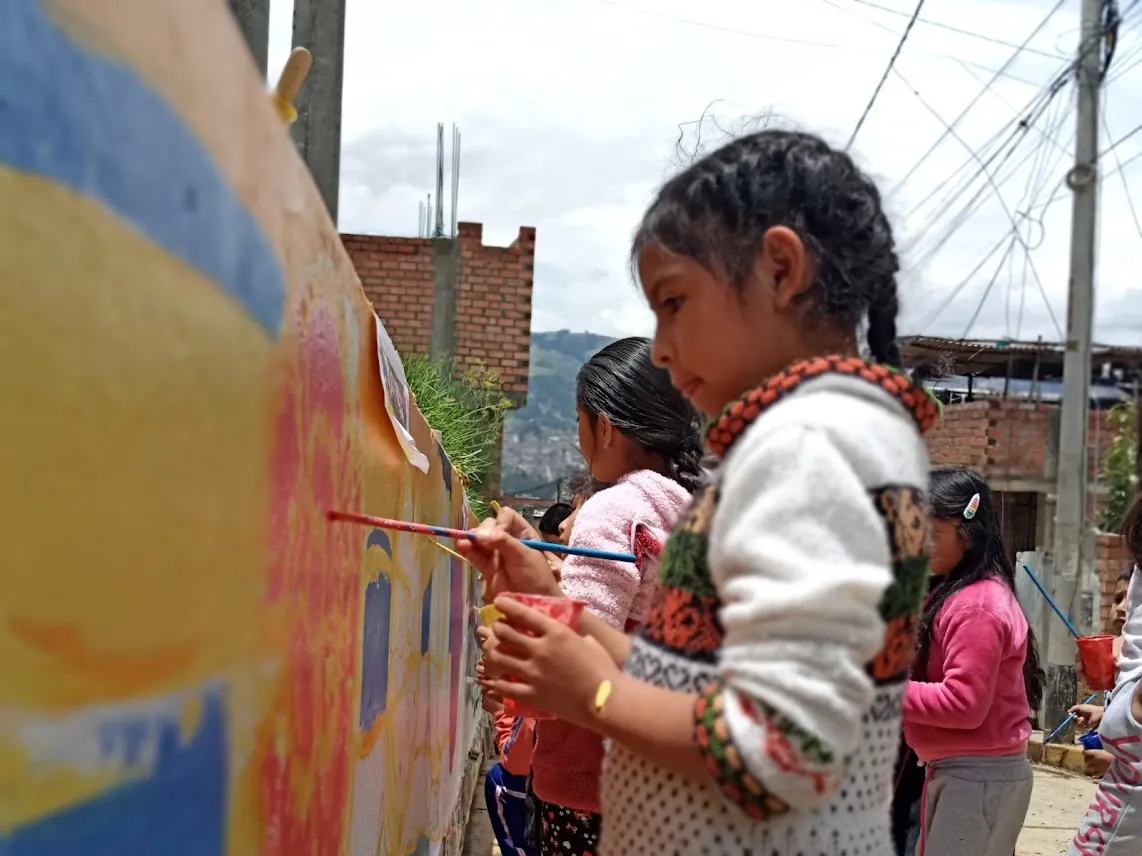 Niñas pintando un mural con la Casa Cultural Shancayán